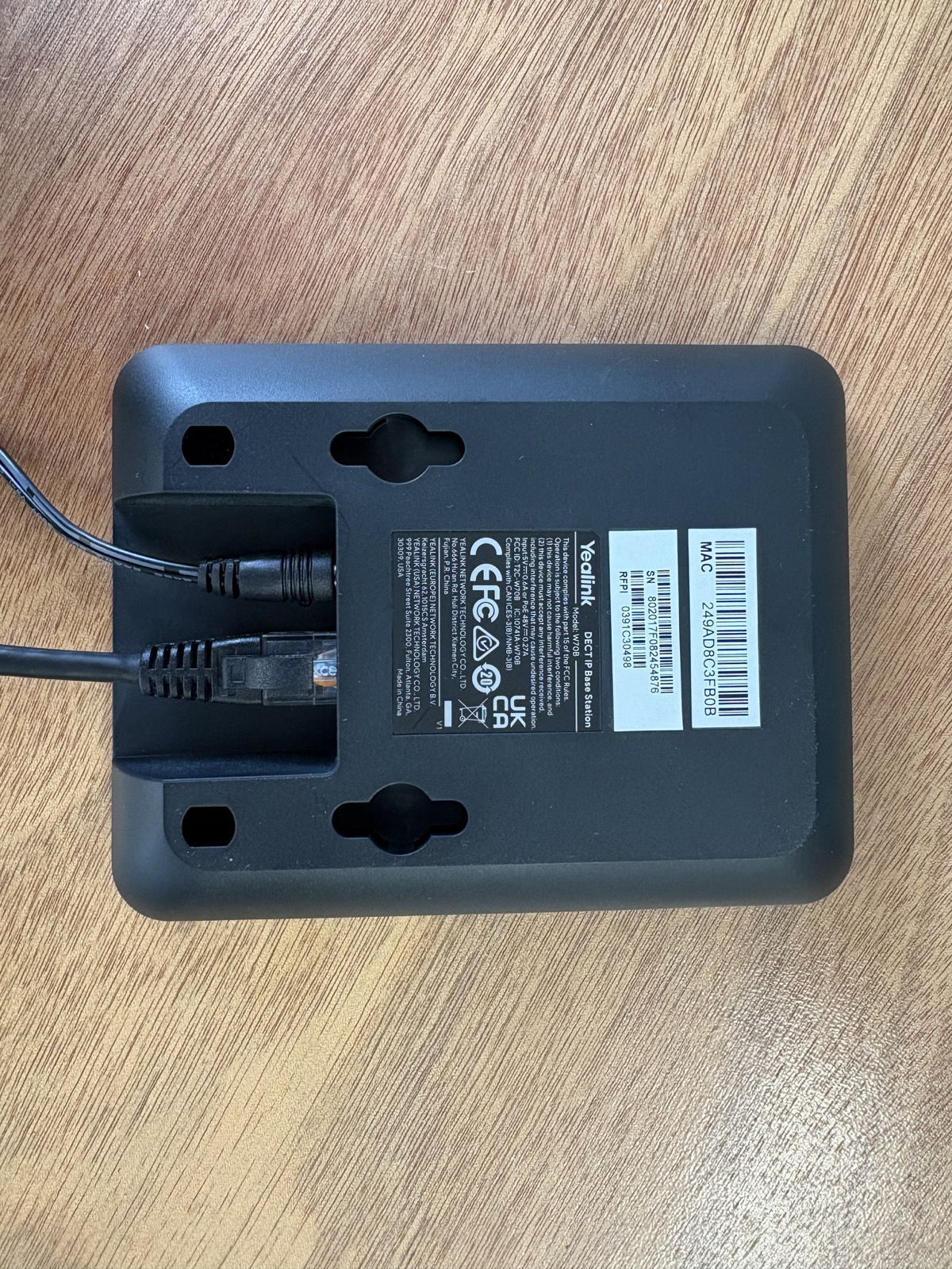 Back of a Yealink W70B base with power and network cables connected